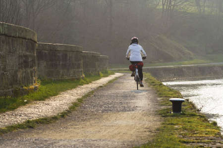 Cyclist on a towpath over an aqueduct by the Forth and Clyde Canalの写真素材