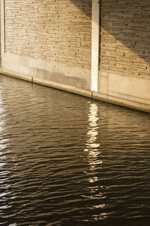 Reflection in a canal under a bridge in the evening Sunの写真素材