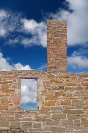 Window and chimney tower in ruined form against cloud and blue skyの写真素材