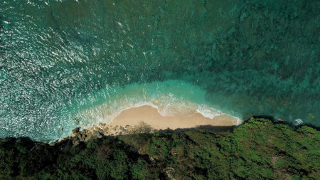 Top-down view of a tiny beach on the ocean, from the back of the beach a cliff.の写真素材