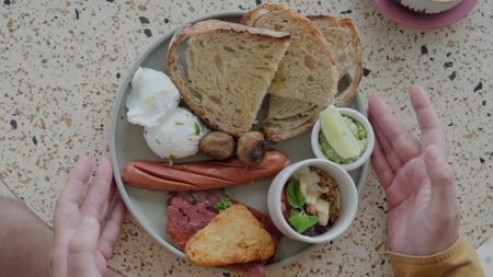 Traditional British breakfast in a plate taken by a man. A close shot breakfast.