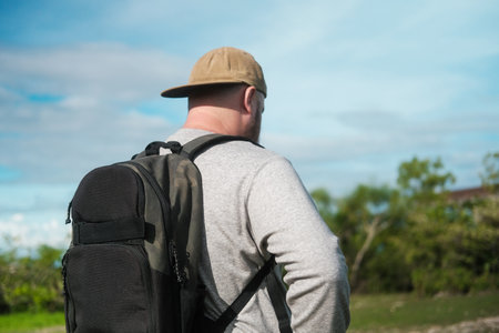 Portrait of a man who is engaged in rucking, training outdoor with a backpack