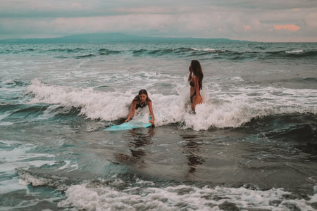 Banner with mom and teenage daughter learning to surf the waves. A beginner surfer catches a wave...