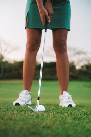 Close-up of the legs of a woman playing golf on the green lawn of a country clubの写真素材