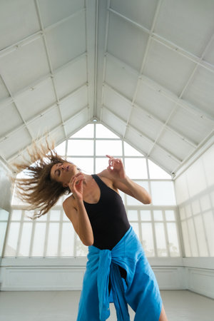 A close-up portrait of a woman dancer gracefully moving her arms and head during a contemporary...