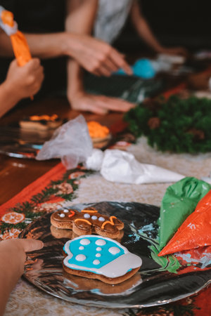 An overhead view of a board displaying Christmas gingerbread cookies baked by children during a holiday workshop. Children baking party. Preparing for New Year and Christmas.の写真素材