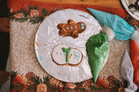 An overhead view of a board displaying Christmas gingerbread cookies baked by children during a...
