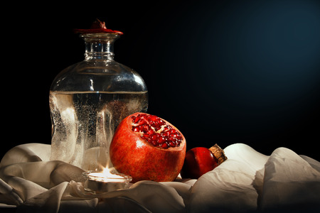 Pomegranate fruit and a bottle of water on the fabric backgroundの写真素材