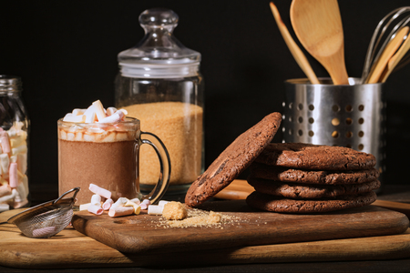 Ream of chocolate cookies on stone board. Black backdround. Kitchen toolsの写真素材
