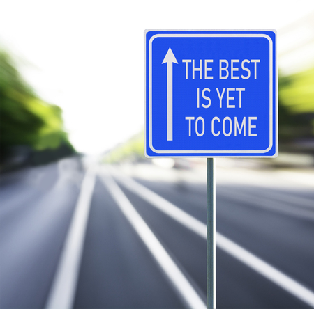 The best is yet to come motivational phrase on blue road sign with arrow and blurred speedy background. Copy space.の写真素材