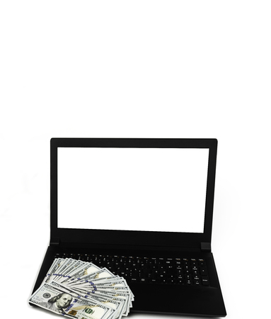 Laptop or notebook with widespread of cash one hundred dollar bills isolated on white background with clean blank display. Template, mock up.の写真素材
