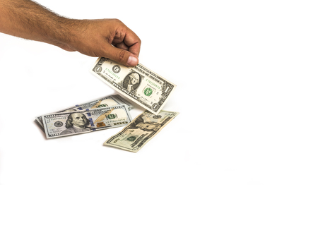 Money, hand is holding one dollar bill with stack of american one hundred dollar bills sorted and twenty dollar note isolated on white background. Copy space.の写真素材