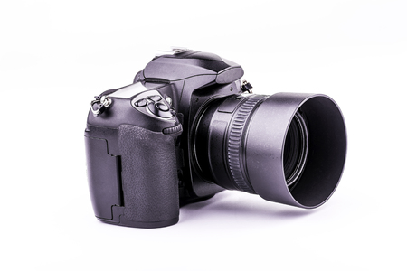 Modern black digital photo camera or dslr with interchangeable lens and lens hood isolated on whiteの写真素材