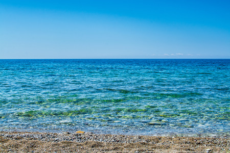 Calm sea or ocean with beach and shallow water - Summer coastline background - Horizon sealine over oceanの写真素材