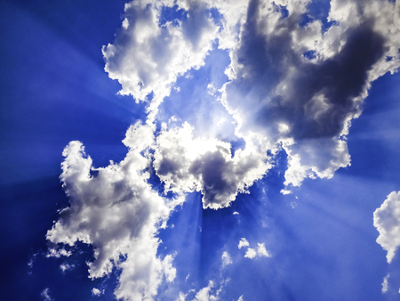 Bottom to top view of dramatic clouds with sun rays coming through - Sky clouds sun rays background