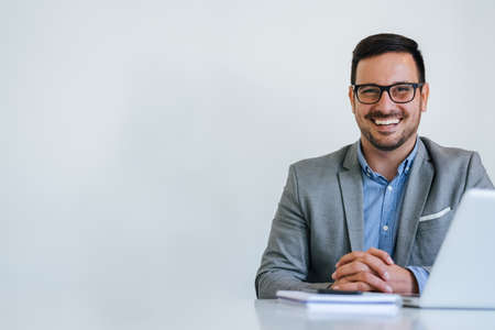 Banner panorama close up mid section body of young smiling cheerful successful businessman entrepreneur in modern bright office on video conference call or chat working from homeの写真素材