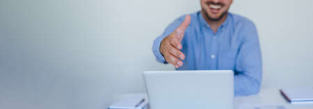 Banner panorama close up mid section body of young smiling cheerful successful businessman entrepreneur in modern bright office on video conference call or chat working from homeの写真素材