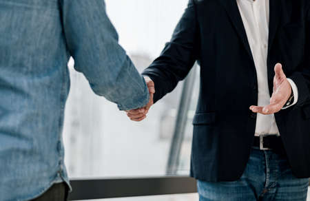 Close up shot of businessmen entrepreneurs freelancers shaking hands greeting each other making a...