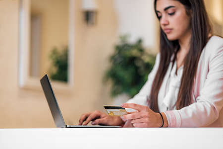 Young adult woman doing online shopping, e-shopping satisfied entrepreneur making online payment...