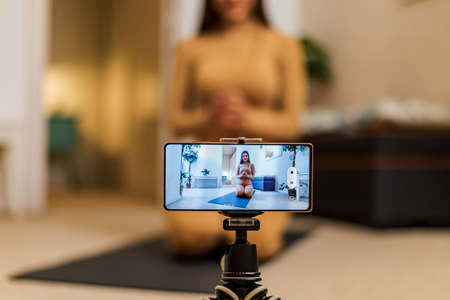 Attractive young girl woman with big smile at her home having fun taking light cheerful selfie. Cool cheerful girl having video call shooting selfies at cozy home.の写真素材