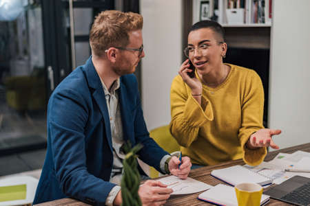 Successful young adult professional businesspeople working on a new project in an office businessman...
