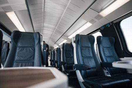Passenger is standing amidst empty seats. Interior of modern illuminated subway or intercity train. Concept of rail transportation.の写真素材
