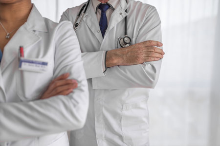 Picture of two hospital colleagues, standing cross-armed, preparing for their shift.の写真素材