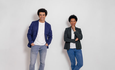 Portrait of smiling young businessman and businesswoman posing confidently over white backgroundの写真素材