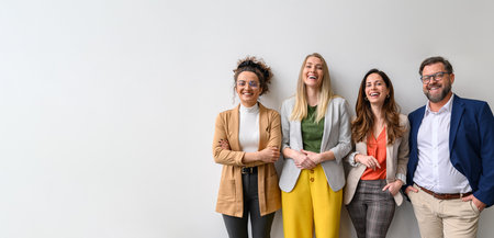 Portrait of smiling male and female business professionals standing and posing together against white backgroundの写真素材