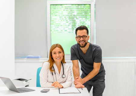 Portrait of confident ophthalmologists working together reviewing documents and collaborating at hospital deskの写真素材