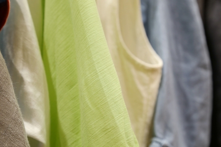 Clothes hang on a shelf in a designer clothes storeの写真素材