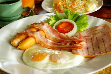 Breakfast set with eggs, sausages, toasts and fresh vegetable, top with tomato, include tomato sauceの写真素材