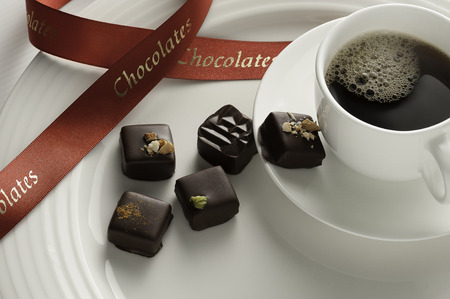 Delicious chocolates with coffee on a white plateの写真素材