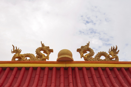 Twins foam crafting dragon with marble in the middle on top of red roof.の写真素材