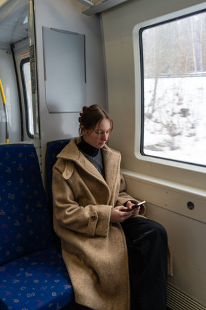 Young Woman Working Remotely on Train During Winter Travel.