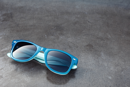 blue sunglasses and grunge concrete glossy backgroundの写真素材