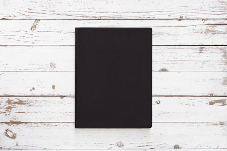 dark notebook on the white wooden tableの写真素材
