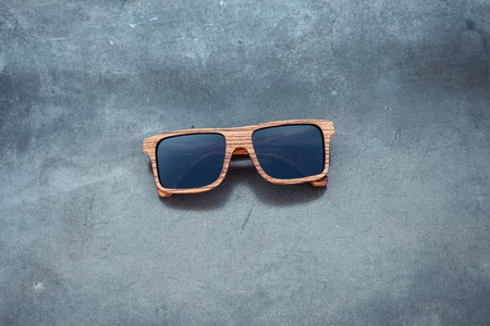 wooden sunglasses and grunge concrete glossy backgroundの写真素材