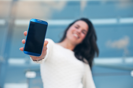 closeup mobile smartphone in hand of beautiful womanの写真素材