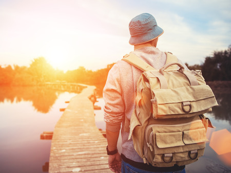 traveler walking over wooden bridge in sunsetの写真素材