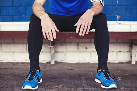 young male athlete resting on the benchの写真素材