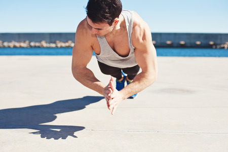 young athletic man doing sport exercise outdoors