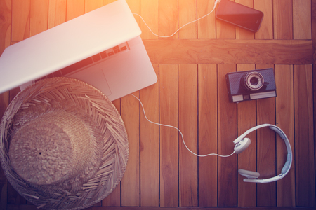 Table for freelancer opened laptop, film camera, mobile phone and headphones, intentional sun glareの写真素材