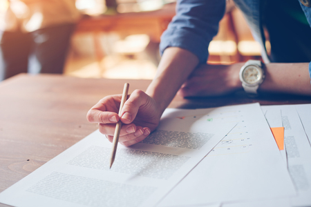 New business plan analyse. Marketing director doing paperwork. Paper and hands on the tableの写真素材