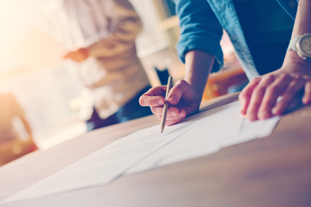 Woman doing paperwork on the table. Open space office. Film effectの写真素材
