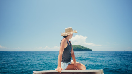 woman floating on the boat near the islandの写真素材