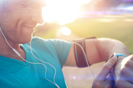 Athlete checking his smart watch on the wrist, intentional sun glare and lens flaresの写真素材
