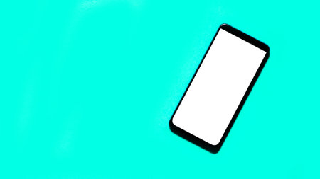 Smartphone on green background top view mockup screen.の写真素材
