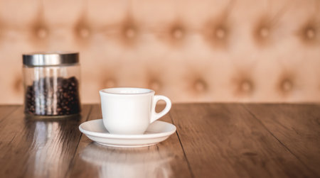 Coffee cup and saucer on a wooden table. Dark background.