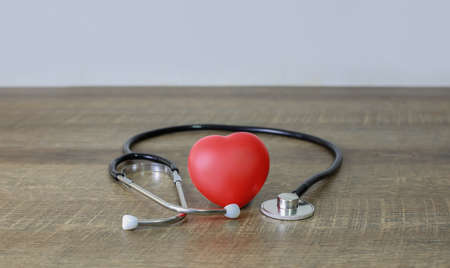 Stethoscope and heart examination red on old wooden floor health care conceptの写真素材